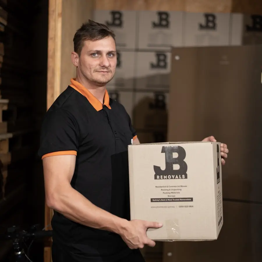 JB Removals team member holding a branded moving box